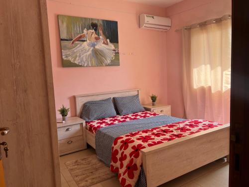 - une chambre dotée d'un lit avec une couverture rouge et blanche dans l'établissement Villa spacieuse et agréable, à Dakar