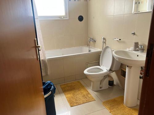 La salle de bains est pourvue de toilettes blanches et d'un lavabo. dans l'établissement Villa spacieuse et agréable, à Dakar
