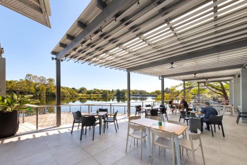 a patio with tables and chairs and a view of the water at Best Western Plus North Lakes Hotel in North Lakes