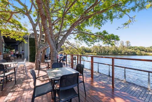 a patio with tables and chairs next to the water at Best Western Plus North Lakes Hotel in North Lakes