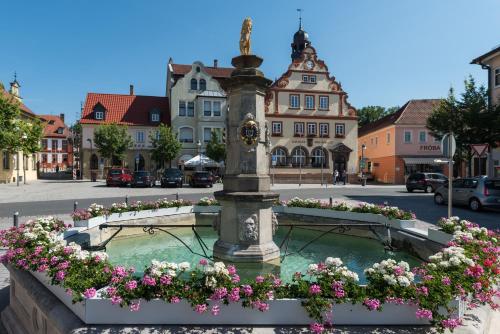 a fountain in the middle of a street with flowers at Lilium Resort Hotel & Restaurant in Bad Rodach