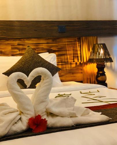 two swans making a heart on a bed at Sand Inn Residence in Kamadhoo