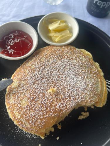 einen Pfannkuchen auf einem Teller mit Butter und Sirup in der Unterkunft Bintana Sa Paraiso in Mambajao