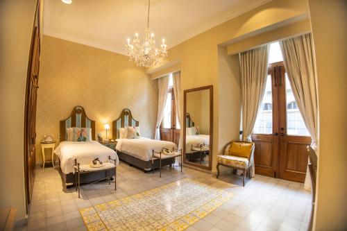 sypialnia z 2 łóżkami i żyrandolem w obiekcie La Concordia - Boutique Hotel w Panamie