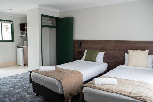 a hotel room with two beds and a table at Wallaby Hotel in Gold Coast