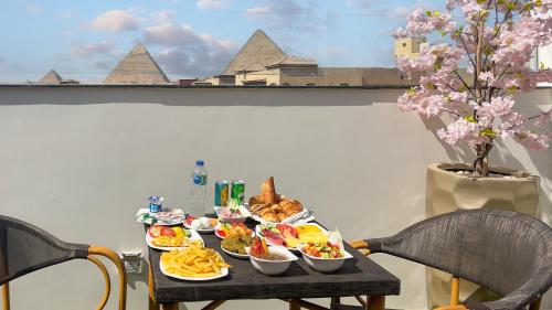 een tafel met borden eten op een tafel met stoelen bij Rizk Pyramids View Hotel in Caïro