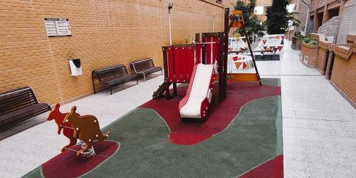 a playground with a slide and a child on a slideintend at Apartamento Neptuno Sunrise Magic World in Oropesa del Mar