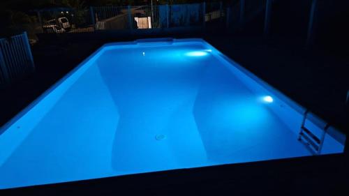 a swimming pool with blue lighting in a dark room at Beautiful Day Studio in Les Trois-Îlets