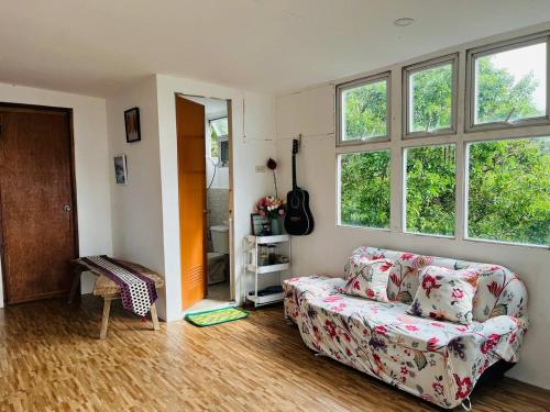 a living room with a couch and two windows at Cabin de Paulin 1 in Tagaytay