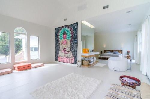 a living room with a large painting on the wall at West Hamptons Zen retreat in Westhampton