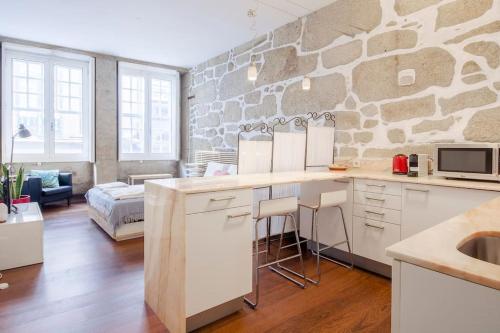 una cucina con parete in pietra e piano di lavoro di OHH - Ganesha studio- Oporto Center a Porto