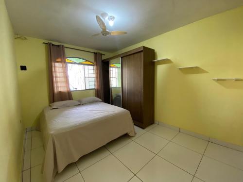 um quarto com uma cama e uma ventoinha de tecto em Casa Camargo - mobiliada, cozinha completa em Campo Grande