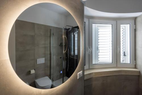 een badkamer met een douche en een toilet in een spiegel bij Lucana Rooftop in Matera