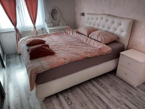 a bedroom with a large bed with pink sheets and pillows at Apartman TT Stan na dan Trn Laktaši in Laktaši