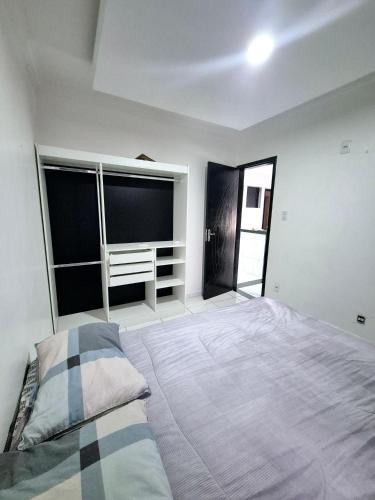 a bedroom with a large bed and large windows at Flat Central do Martins in São Luís