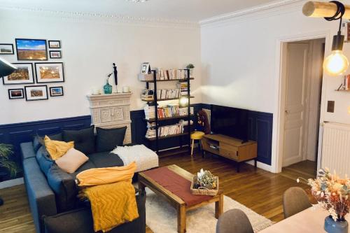 ein Wohnzimmer mit einem blauen Sofa und einem Tisch in der Unterkunft Comfortable 76m apartment in Paris