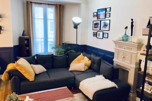 sala de estar con sofá y chimenea en Comfortable 76m apartment en París