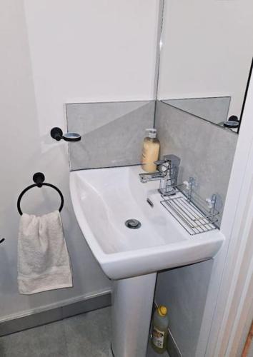 y baño con lavabo blanco y espejo. en 1-bed flat near Romford station, en Romford