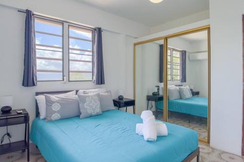 Un dormitorio con una cama azul con un osito de peluche. en Humacao Villa - 8BR, Pool, Palmas, Ocean Views 