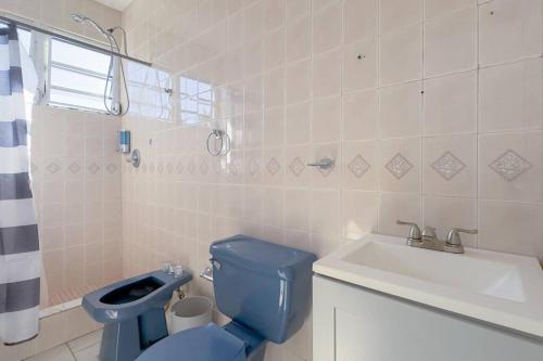 a bathroom with a blue toilet and a sink at Humacao Villa - 8BR, Pool, Palmas, Ocean Views 
