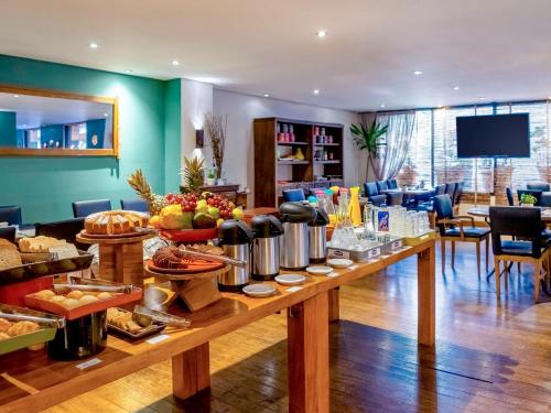 a table with a buffet of food in a room at São Paulo Mercure Moema Times Square - Flat DIAMOND in Sao Paulo