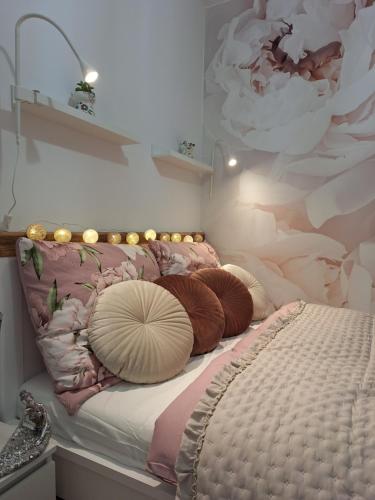 uma cama com almofadas num quarto em Dragon apartament em Lublin