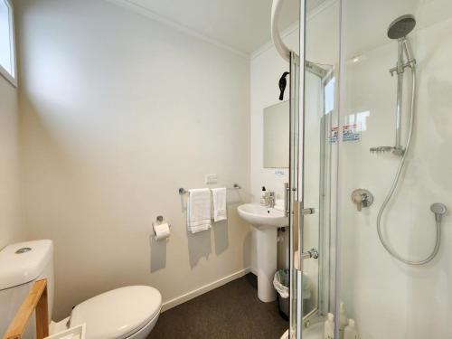 a bathroom with a shower and a toilet and a sink at Hahei Getaway Rua in Hahei