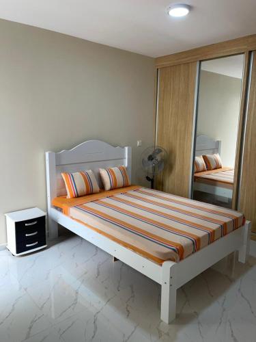 um quarto com uma cama grande e um espelho em madison place em Praia