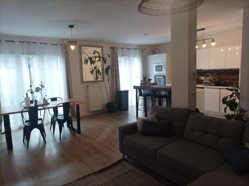 uma sala de estar e cozinha com um sofá e uma mesa em Résidence Juan Valera em Vaujours