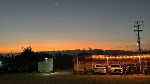 un groupe de voitures garées dans un garage au coucher du soleil dans l'établissement Hotel Luna Azul Tatacoa, à Villavieja