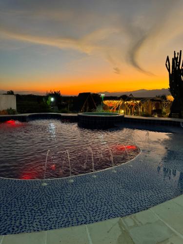 a large pool of water with a sunset in the background at Hotel Luna Azul Tatacoa in Villavieja