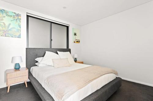 a bedroom with a large bed and a large window at Ocean Views, Deck and Parking at Beach Apartment in Collaroy