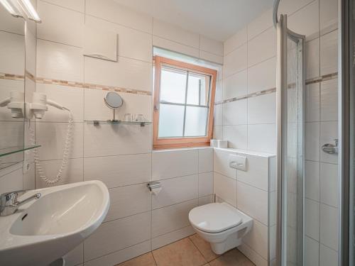 een witte badkamer met een wastafel en een toilet bij Röck II in Neukirchen am Großvenediger