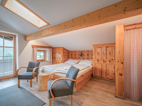 a bedroom with a bed and two chairs in it at Röck III in Neukirchen am Großvenediger
