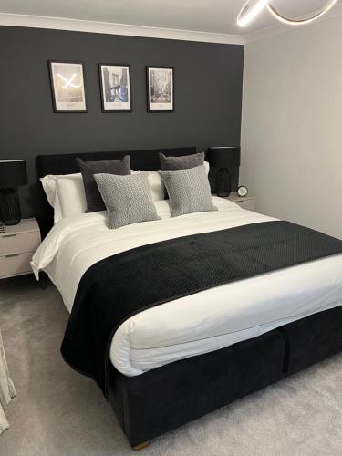 a bedroom with a large bed with black and white pillows at Glenshellach Apartment Oban in Oban