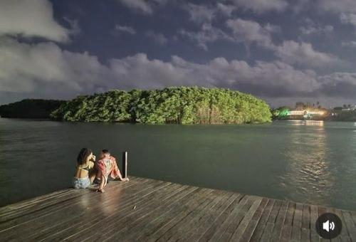 a man and a woman sitting on a dock at RECANTO DO SOL SABIAGUABA CEARA in Fortaleza