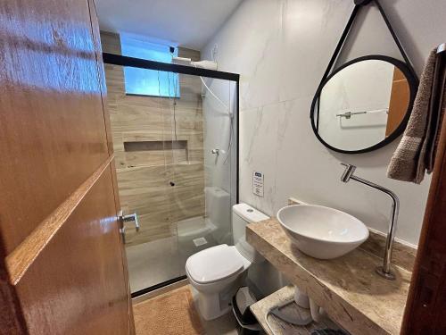 a bathroom with a toilet and a sink and a shower at Morada do Sol Suítes in Arraial do Cabo