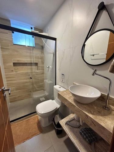a bathroom with a toilet and a sink and a shower at Morada do Sol Suítes in Arraial do Cabo