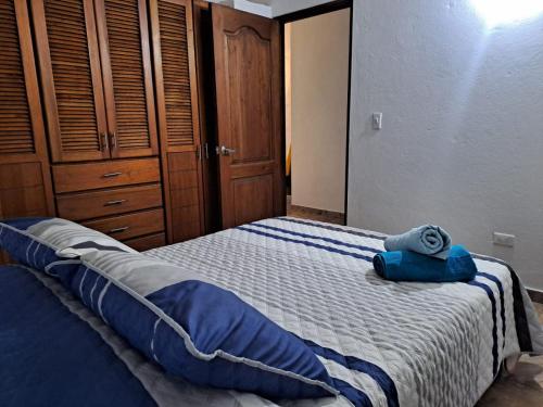 萊瓦鎮的住宿－Apartahotel Sacrosanta Trinidad，一间卧室配有一张带蓝色毛巾的床