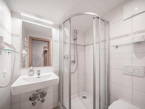 a white bathroom with a sink and a shower at Röck IV in Neukirchen am Großvenediger