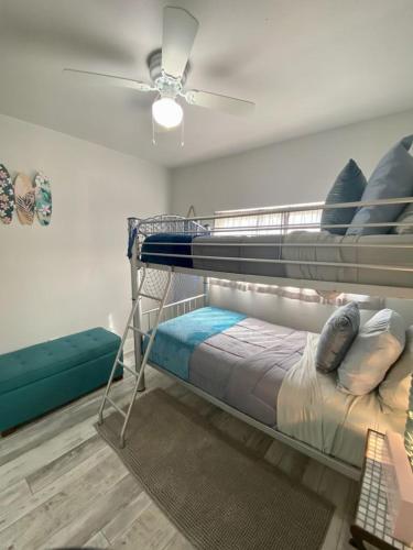 a bedroom with two bunk beds and a ceiling fan at Sandy Haven in Bolivar Peninsula