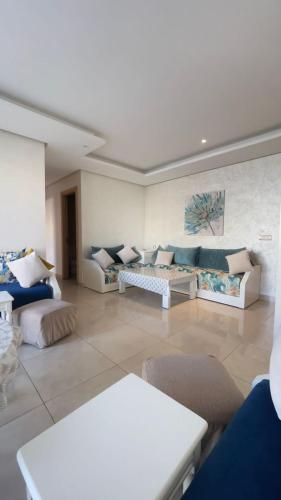 a large living room with couches and tables at Appartement Prestigia des nations in Salé