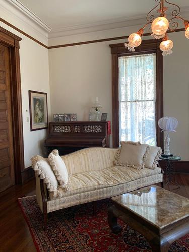 een woonkamer met een bank en een tafel bij Historic Queen Anne Mansion in Quincy