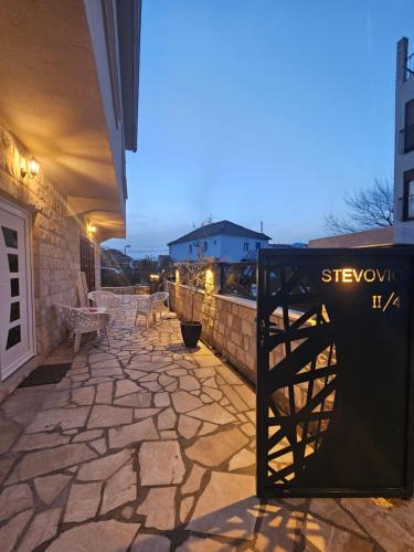 - une terrasse en pierre avec une table et des chaises dans un bâtiment dans l'établissement Studio apartmani Vukasin, à Tivat