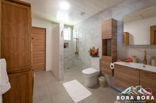 uma casa de banho com um WC e um lavatório em Matira Beach House em Bora Bora