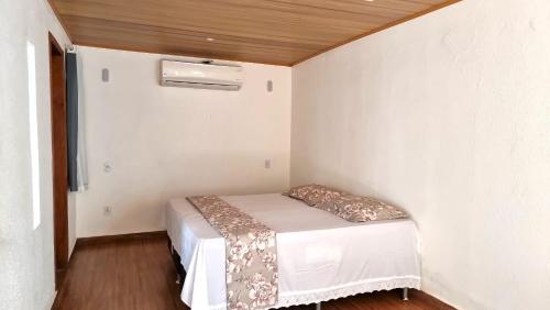 a small bedroom with a bed in a room at Penedo Chalés Bela Vista 10 in Itatiaia