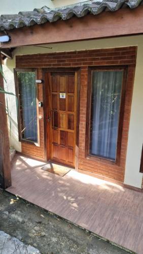 a wooden door of a house with a porch at Penedo Chalés Bela Vista 10 in Itatiaia