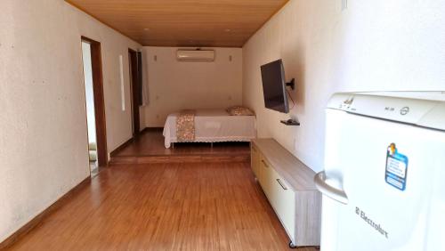 a small room with a bed and a tv in it at Penedo Chalés Bela Vista 10 in Itatiaia