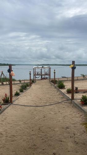 Baixa Grande的住宿－Chalé flores do Velho Chico，通往海滩的木板路,设有天篷