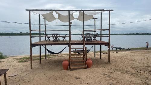 Baixa Grande的住宿－Chalé flores do Velho Chico，海滩上的桌椅和遮阳伞